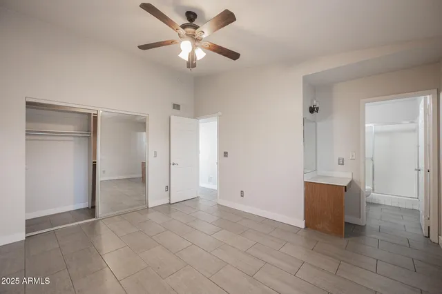 an empty room with closet and windows