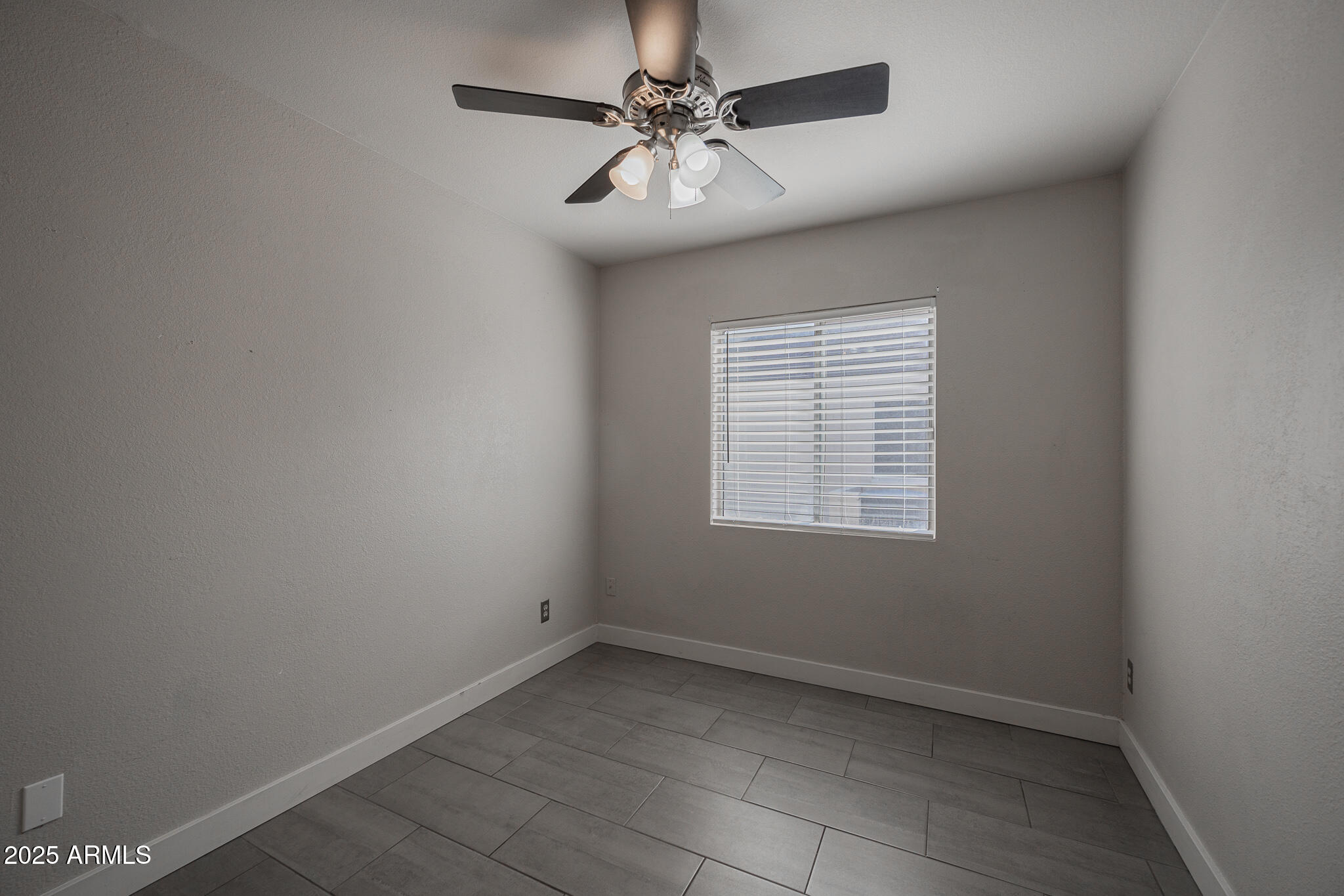 1025 West Laguna Drive Tempe, AZ 85282 - Photo 13 of 20 an empty room with a chandelier fan and windows