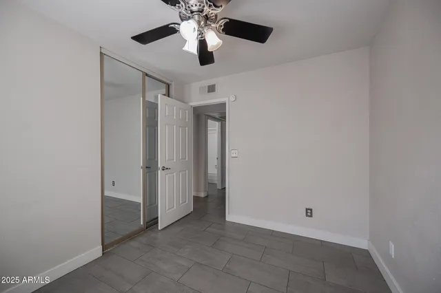 an empty room with a ceiling fan and a chandelier fan