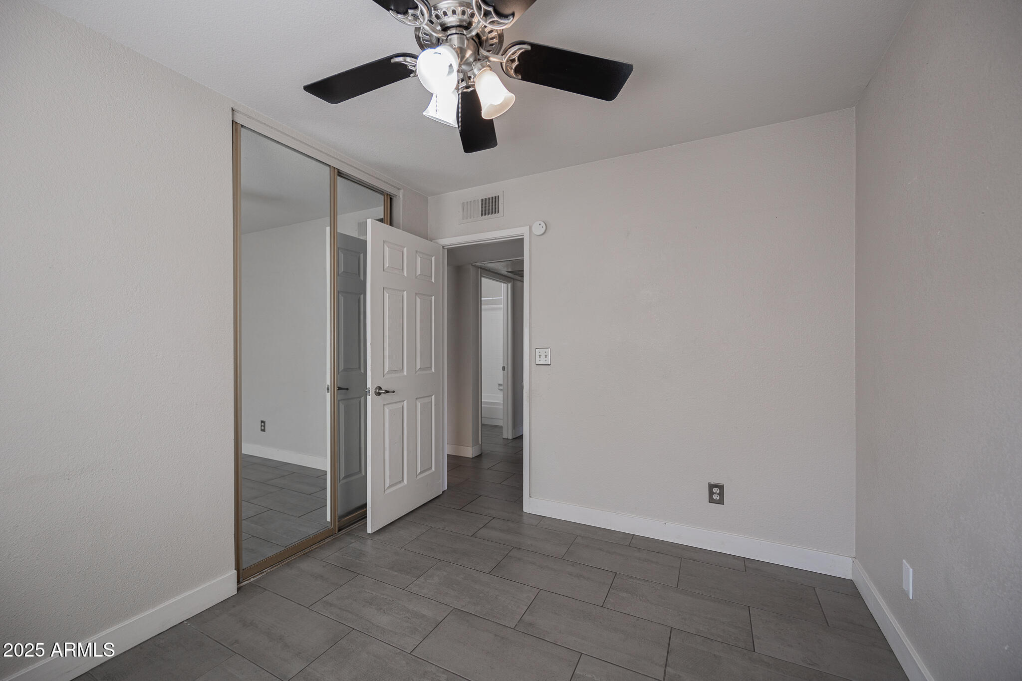 1025 West Laguna Drive Tempe, AZ 85282 - Photo 14 of 20 an empty room with a ceiling fan and a chandelier fan