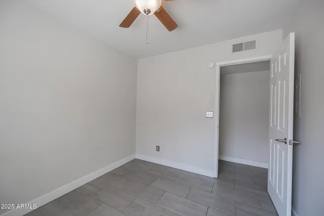 an empty room with a empty space and a ceiling fan