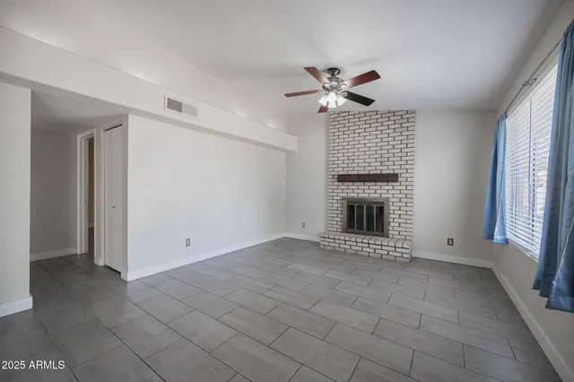 a view of an empty room with a fireplace and a window