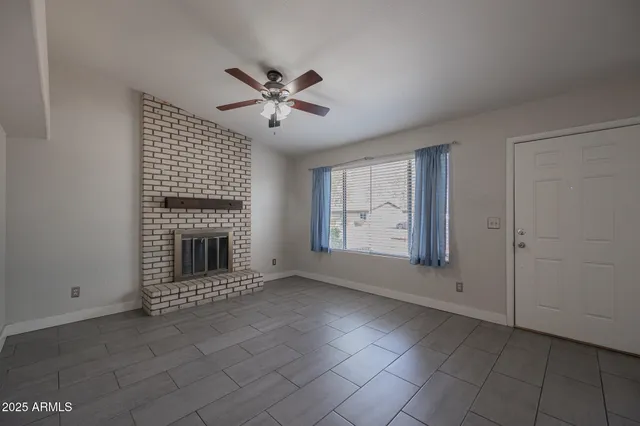 a view of an empty room with a fireplace and a window