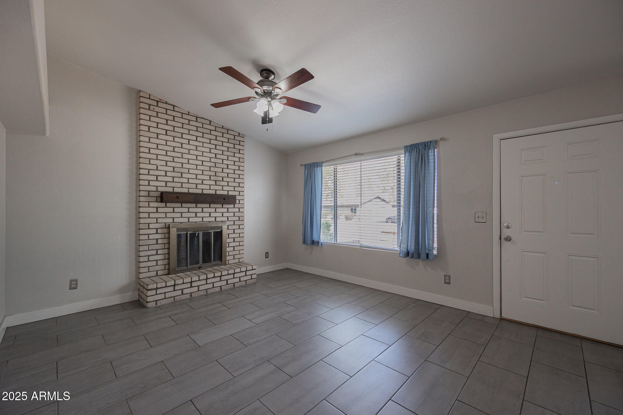 1025 West Laguna Drive Tempe, AZ 85282 - Photo 5 of 20 a view of an empty room with a fireplace and a window