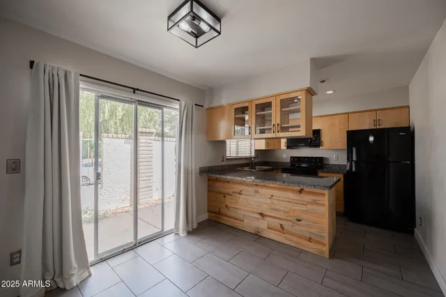a kitchen with granite countertop a refrigerator and a sink