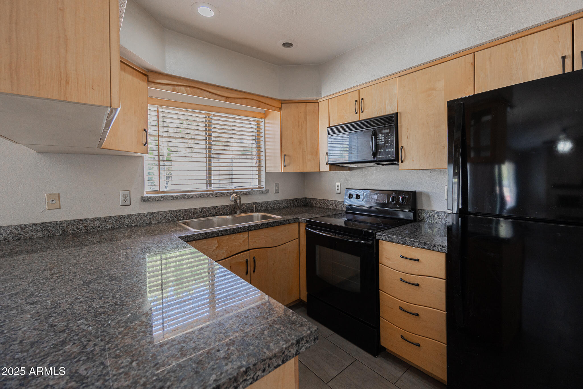 1025 West Laguna Drive Tempe, AZ 85282 - Photo 9 of 20 a kitchen with stainless steel appliances granite countertop a stove a sink and a microwave