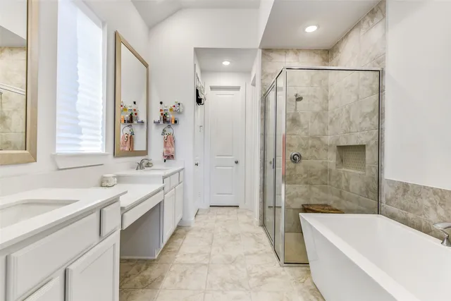 a spacious bathroom with a tub sink shower and mirror