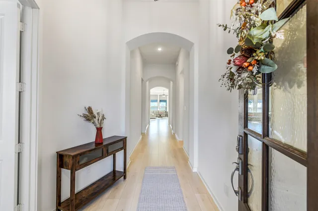 a view of a hallway with wooden floor and a potted plant