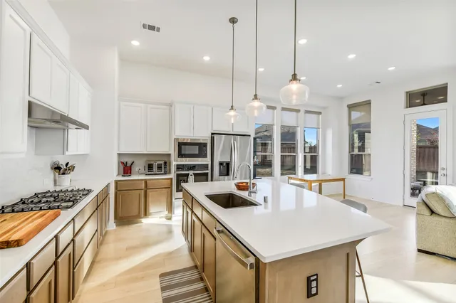 a kitchen with a stove a kitchen island a sink and a refrigerator