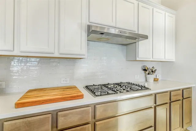 a kitchen with white cabinets and a stove