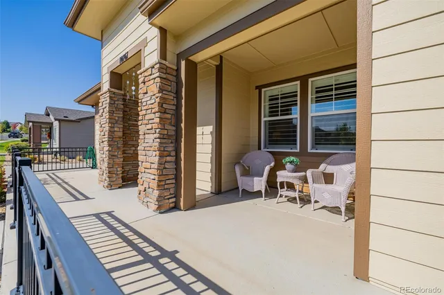 a view of a patio with table and chairs with wooden floor and fence