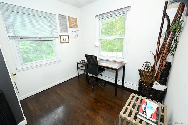 a view of a workspace with furniture and a window