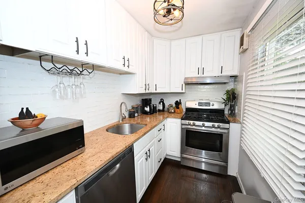 a kitchen with stainless steel appliances granite countertop a sink and a stove
