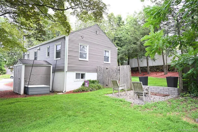 a view of a house with backyard and a tree