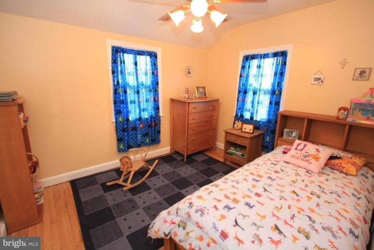 9924 Grayson Avenue Silver Spring, MD 20901 - Photo 3 of 26 a bedroom with a bed and a table in it