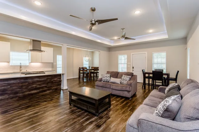 a living room with furniture a ceiling fan and a rug