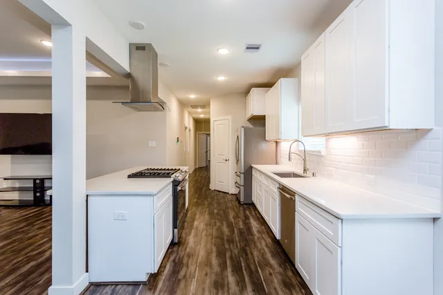 a kitchen with a sink a counter top space stainless steel appliances and a window