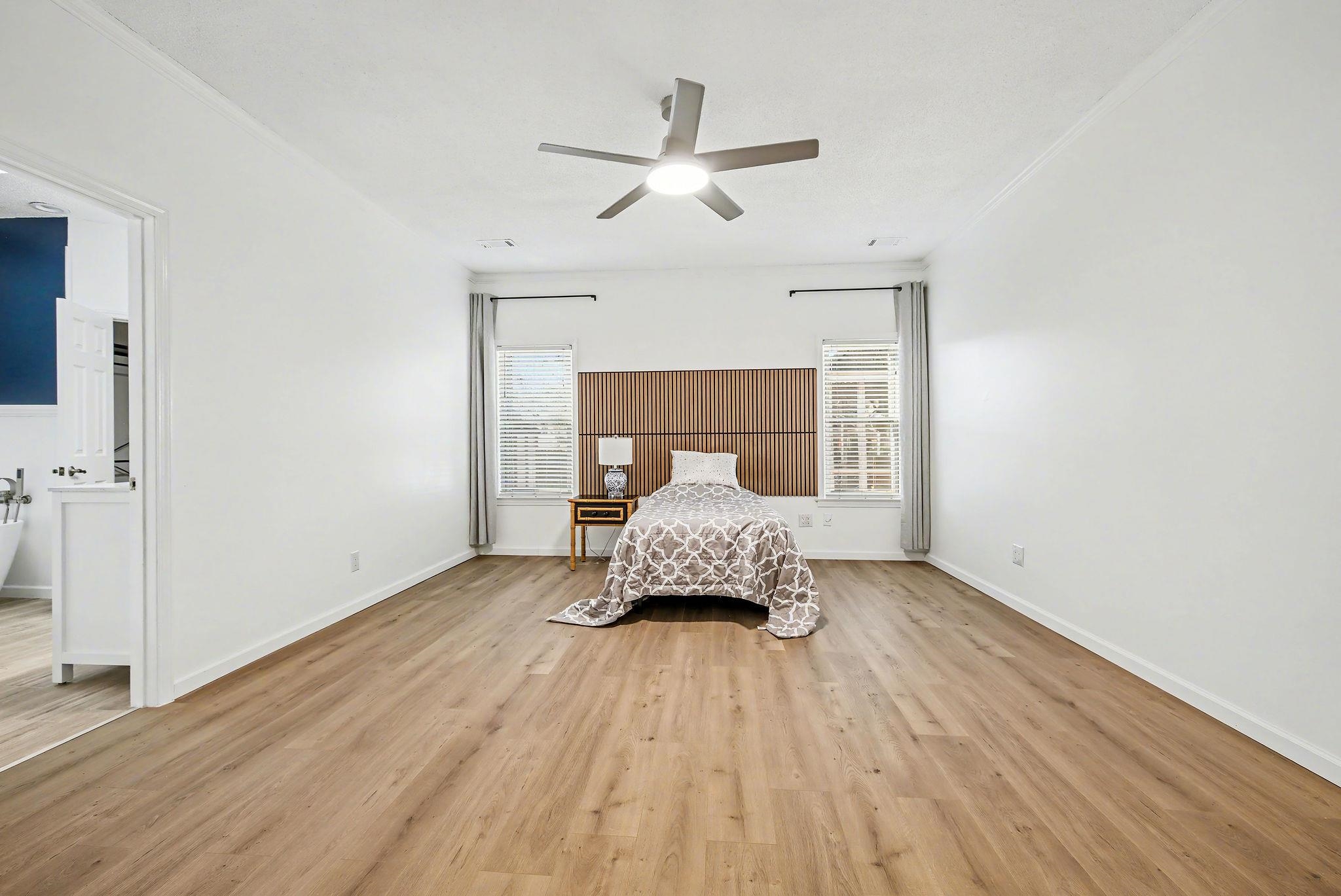 8431 Bazemore Road Cordova, TN 38018 - Photo 12 of 23 Bedroom with crown molding, light wood-style flooring, multiple windows, ceiling fan, and ensuite bath.