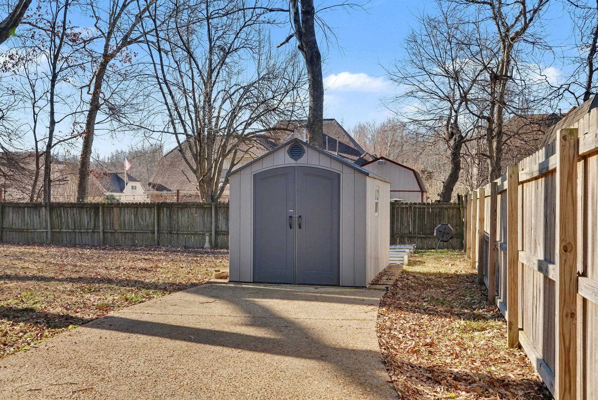 8431 Bazemore Road Cordova, TN 38018 - Photo 22 of 23 Gated back driveway leading to large storage shed and raised garden plots behind it.