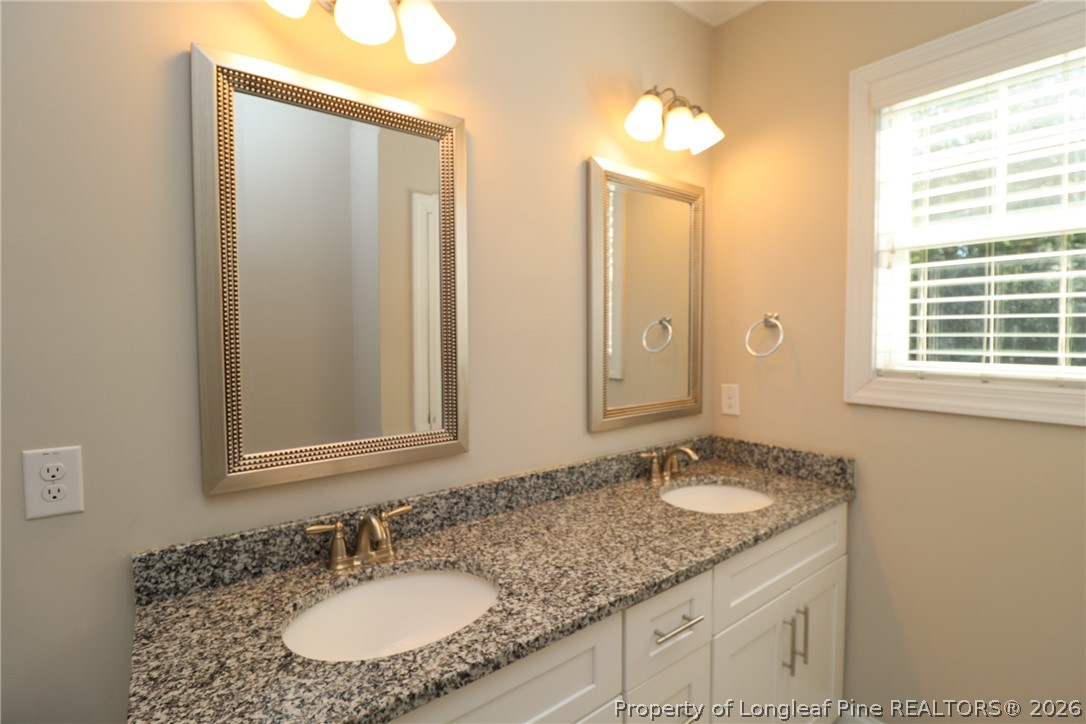 8424 Rhodes Road Apex, NC 27539 - Photo 20 of 31 a bathroom with a granite countertop sink and a mirror