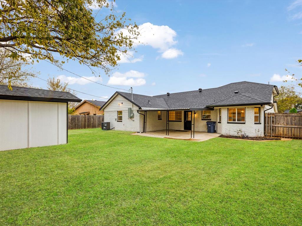 916 Kelley Drive Everman, TX 76140 - Photo 22 of 35 Back of property featuring a patio, brick siding, a fenced backyard, and a shingled roof