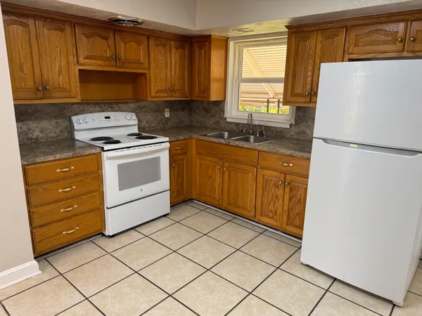 a kitchen with a refrigerator sink and cabinets