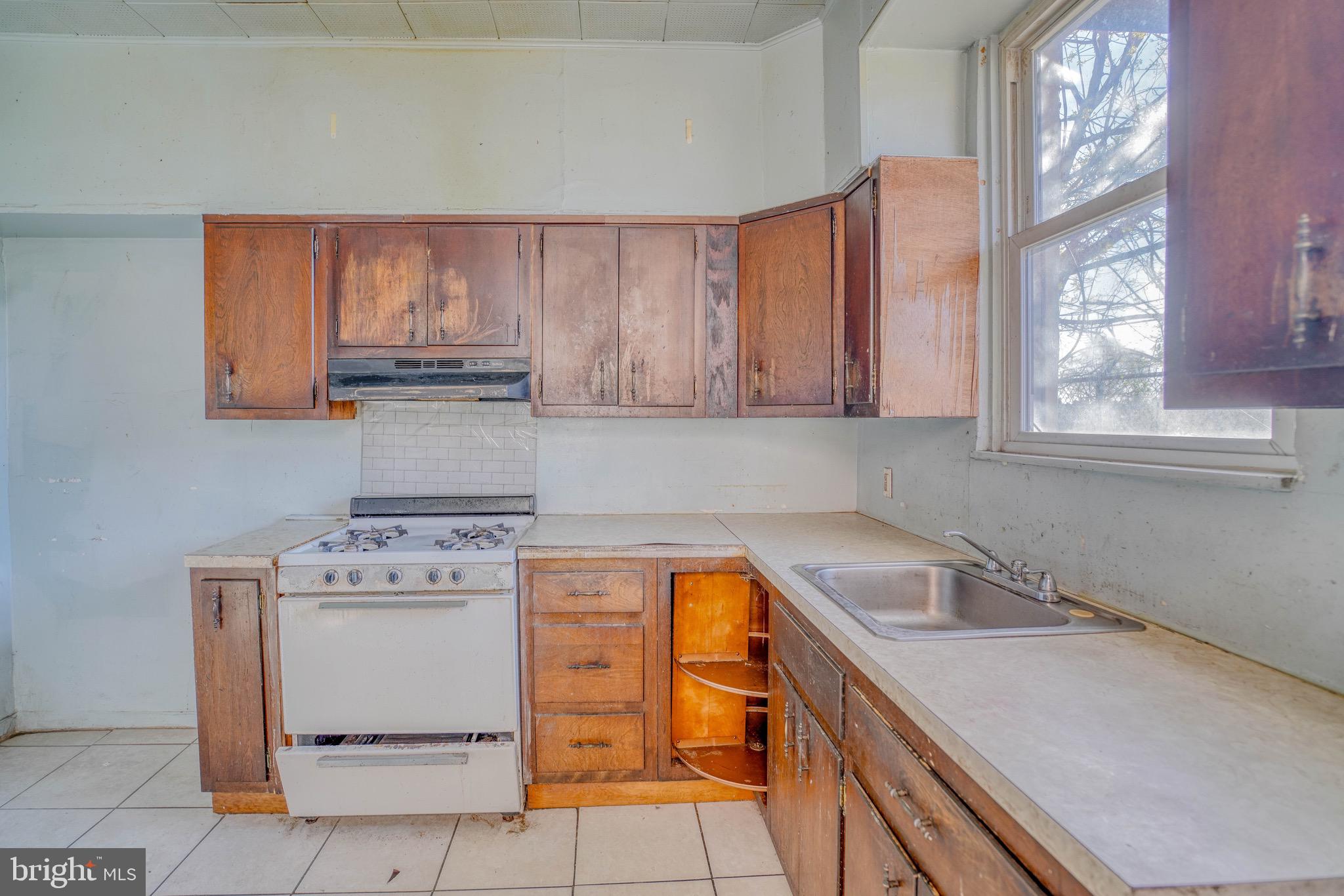 5705 Leonard Street Philadelphia, PA 19149 - Photo 15 of 30 a utility room with stainless steel appliances granite countertop a sink stove and cabinets