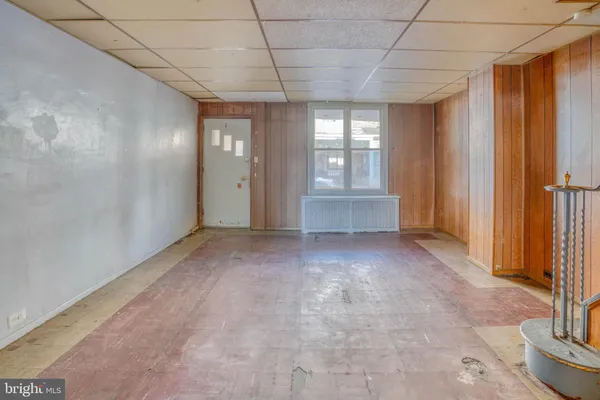 a view of empty room with window and wooden floor