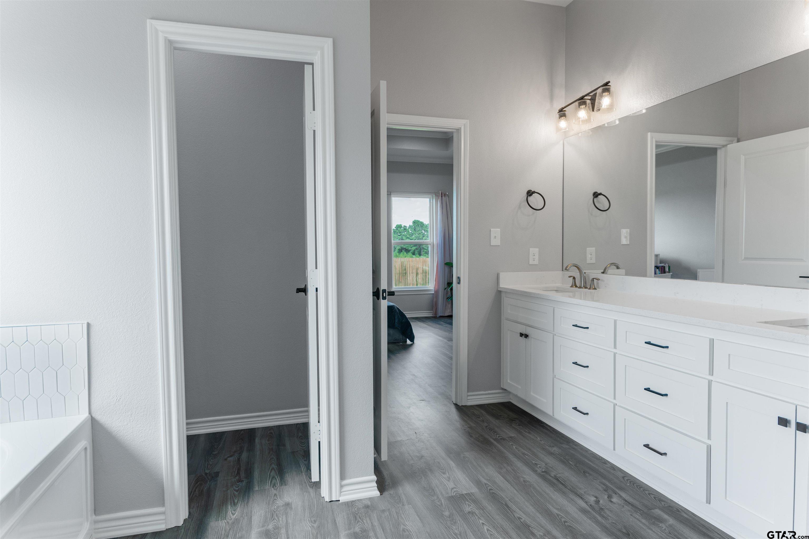 12908 County Road 46 Tyler, TX 75704 - Photo 20 of 24 a spacious bathroom with a double vanity sink and a mirror