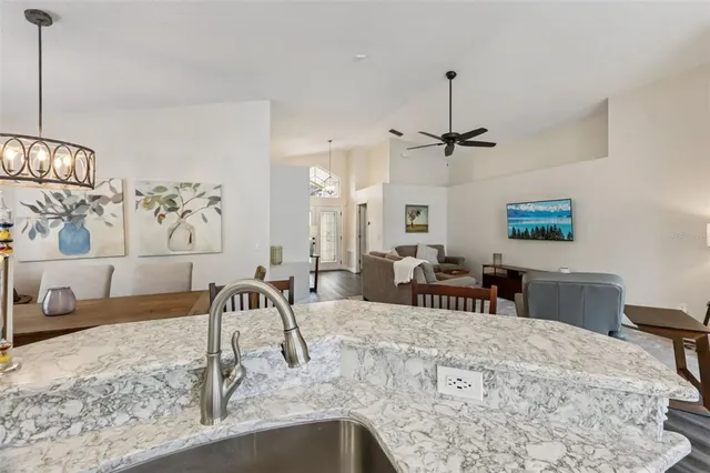 a bathroom with a granite countertop toilet a sink a mirror and a window