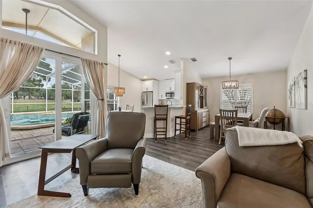 a living room with furniture a chandelier and a flat screen tv