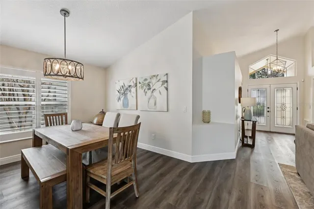 a dining room with furniture a chandelier and wooden floor