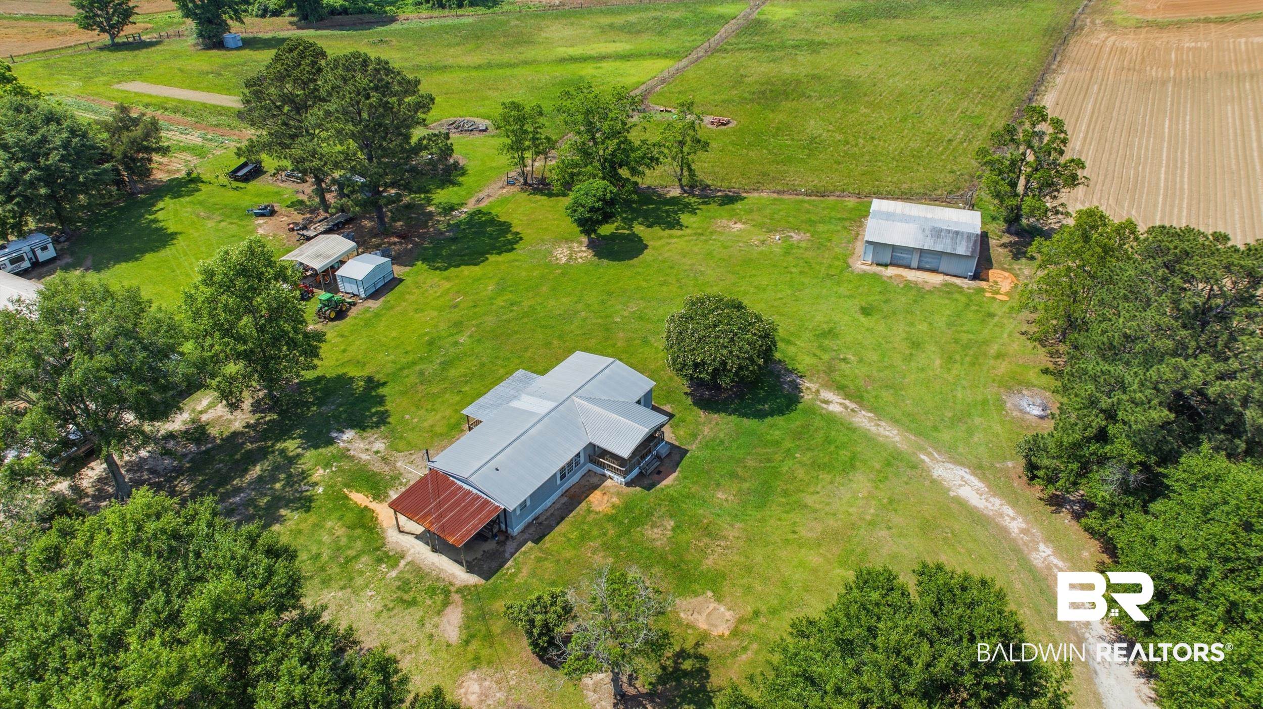 926 Tumbling Lane Atmore, AL 36502 - Photo 56 of 56 Expansive rural property featuring a primary residence with a metal roof and a covered porch