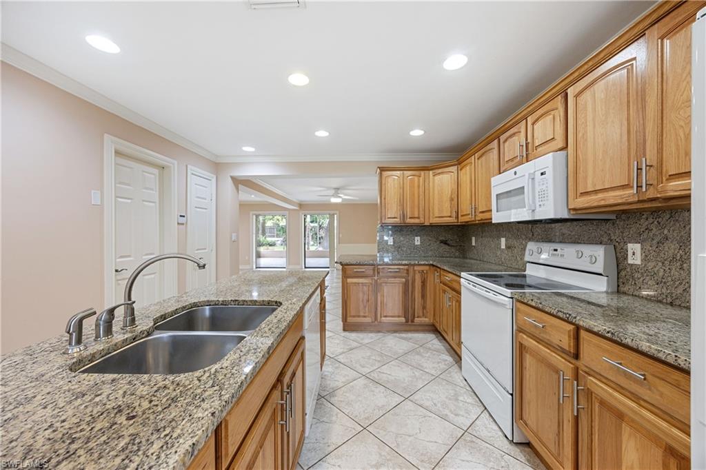 1120 Ridge Street Naples, FL 34103 - Photo 2 of 39 Kitchen, lots of counter space and cabinetry for storage. Crown molding, stone countertops, backsplash, and light tile patterned flooring. Recessed lighting.