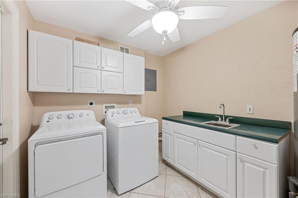 1120 Ridge Street Naples, FL 34103 - Photo 20 of 39 Laundry area featuring cabinet space, washing machine and clothes dryer, More cabinetry and counter space including sink. Ceiling fan.