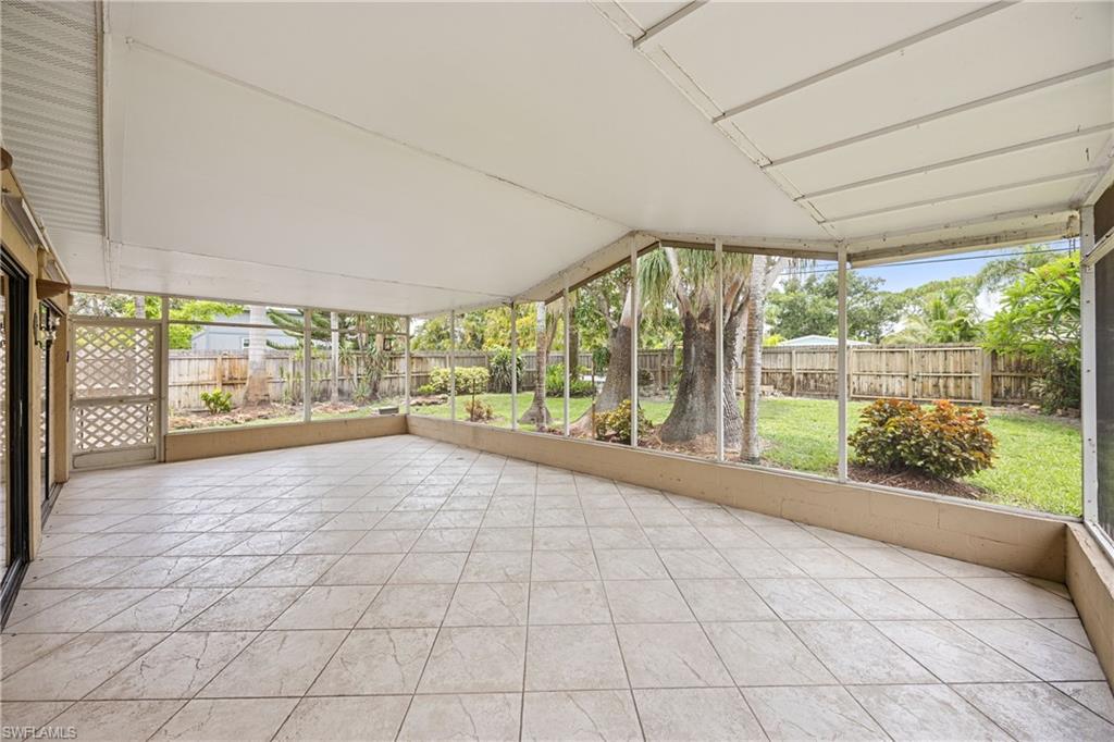 1120 Ridge Street Naples, FL 34103 - Photo 34 of 39 Oversized screened-in Lanai featuring lofted ceiling, tile floor, view of landscaped yard, beautiful mature trees.