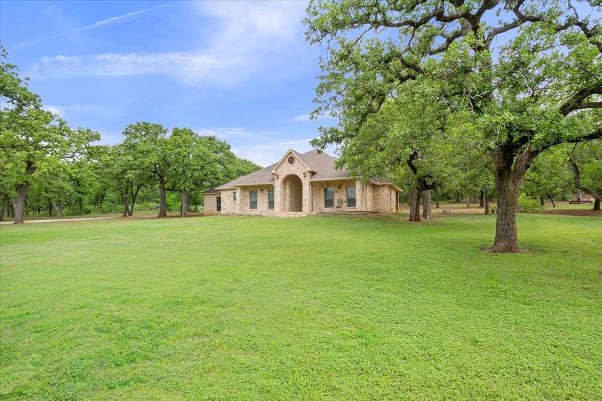 140 Oak Ridge Loop Whitney, TX 76692 - Photo 3 of 40 a front view of a house with a garden