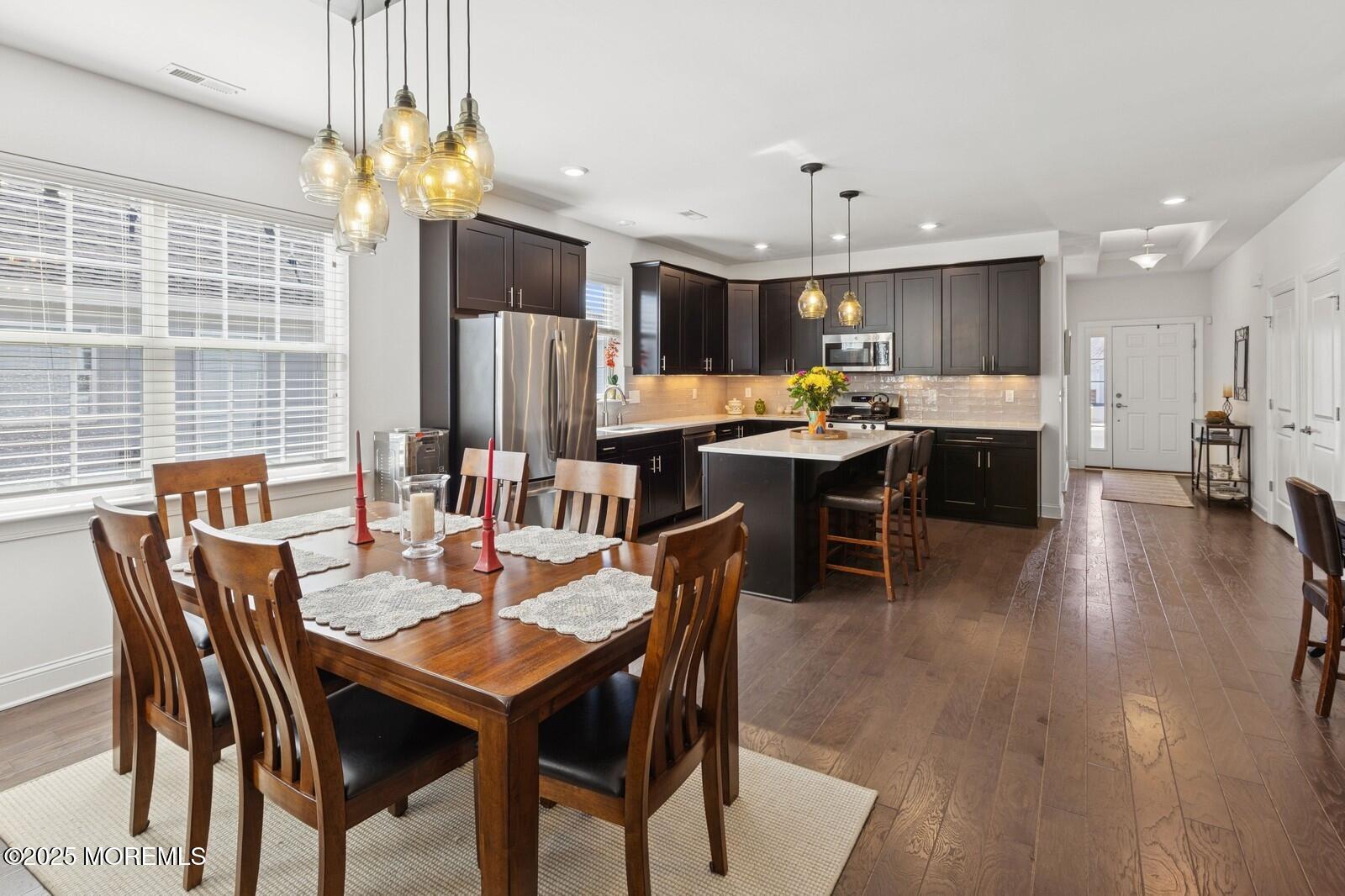 60 Butler Drive Barnegat, NJ 08005 - Photo 15 of 59 a dining room with wooden floor a chandelier a glass table and chairs