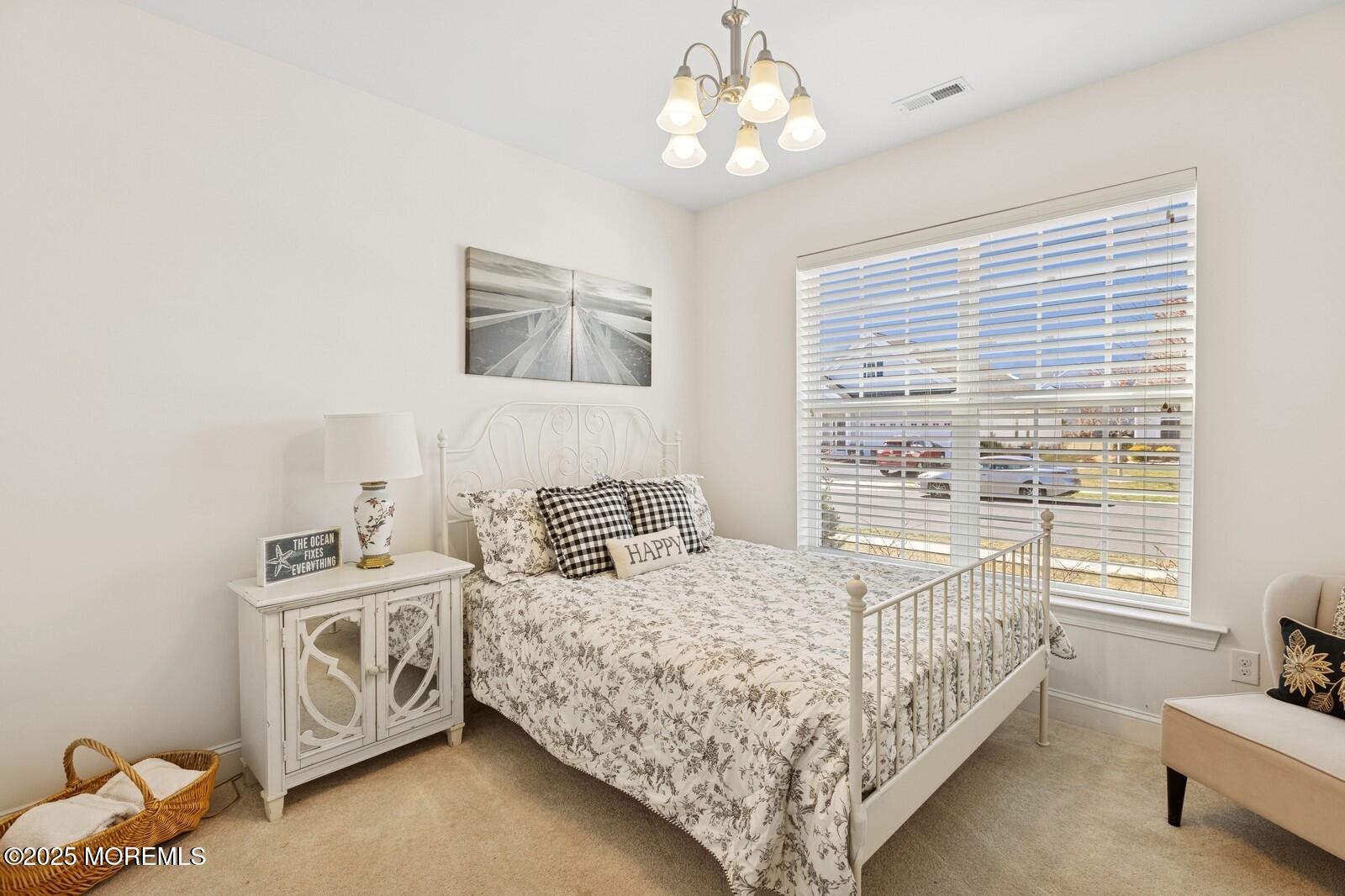 60 Butler Drive Barnegat, NJ 08005 - Photo 41 of 59 a bedroom with a bed and a chandelier