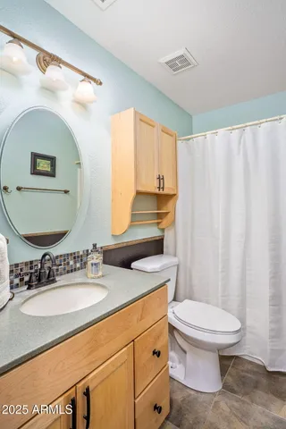 a bathroom with a sink a toilet and a mirror