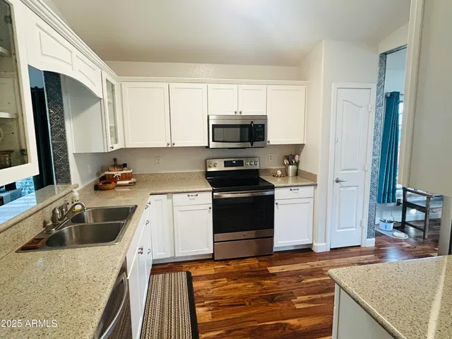 a kitchen with granite countertop a sink stove and refrigerator