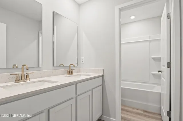 a bathroom with a double vanity sink and a mirror