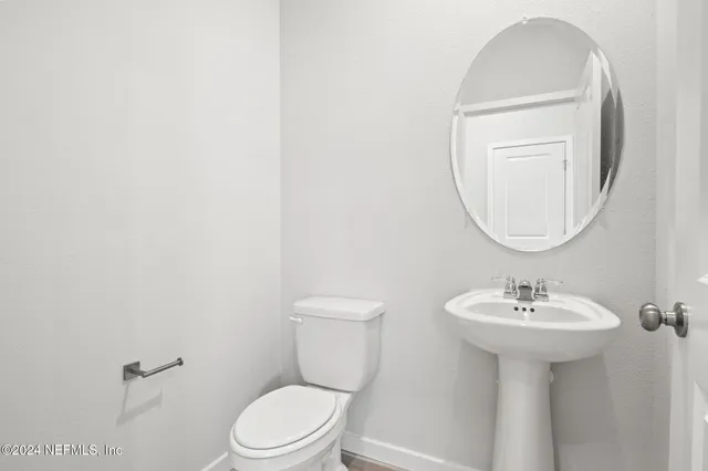 a bathroom with a sink a toilet and a mirror