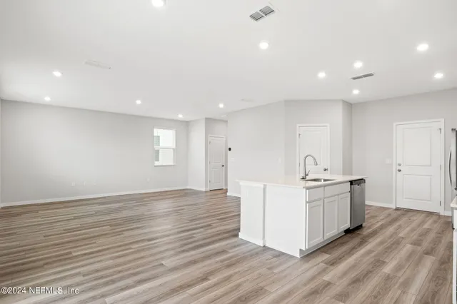 a kitchen with stainless steel appliances a white stove top oven and white cabinets