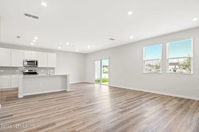 a view of kitchen with wooden floor and electronic appliances