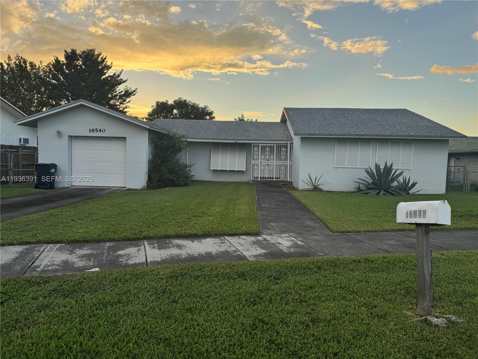 a view of a house with a big yard and a large tree