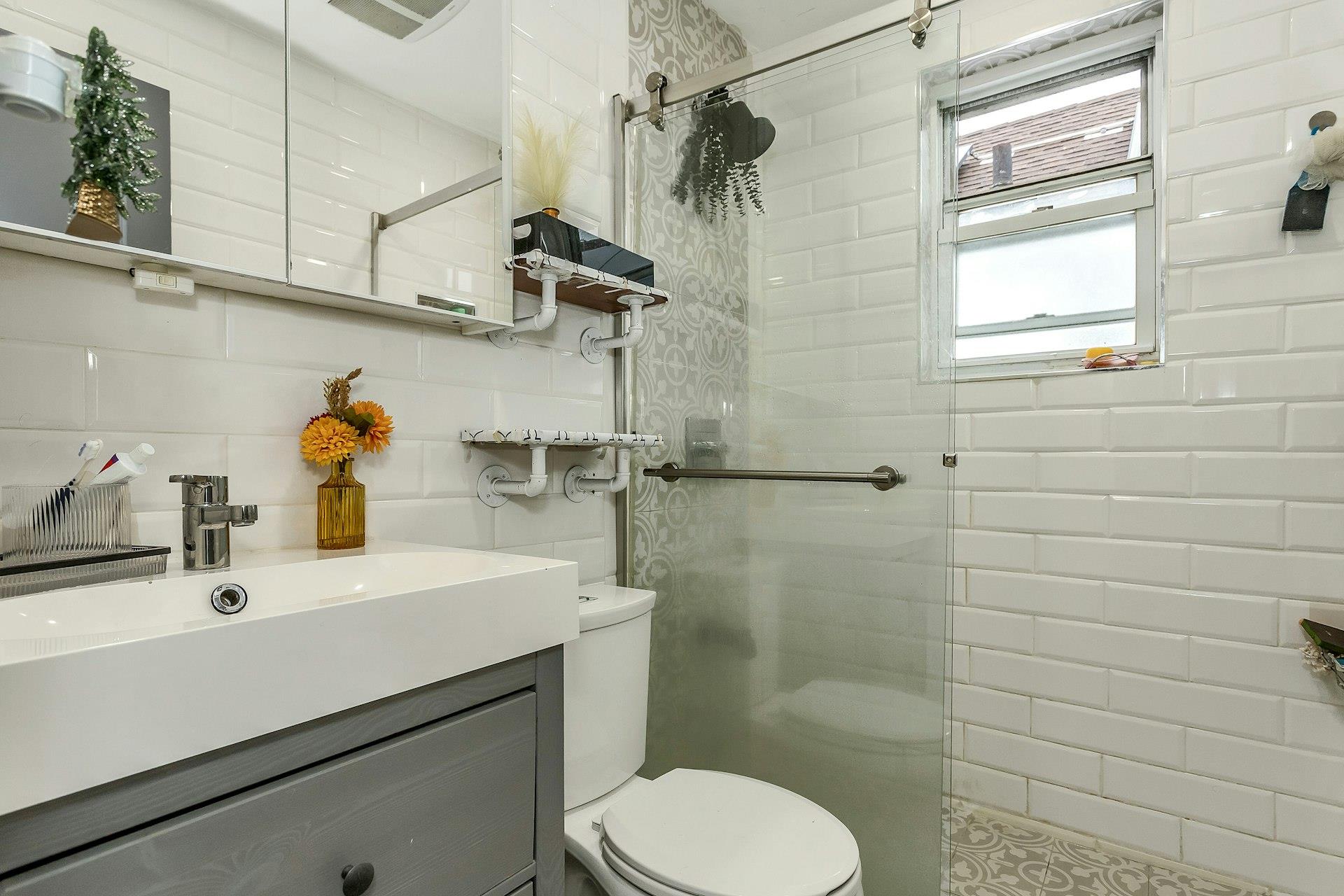111-32 147th Street Queens, NY 11435 - Photo 11 of 24 Bathroom with tiled shower, toilet, tile walls, and vanity