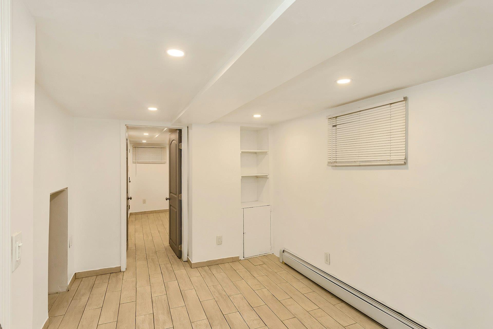 111-32 147th Street Queens, NY 11435 - Photo 17 of 24 Empty room with light wood-style flooring, recessed lighting, baseboards, and a baseboard radiator