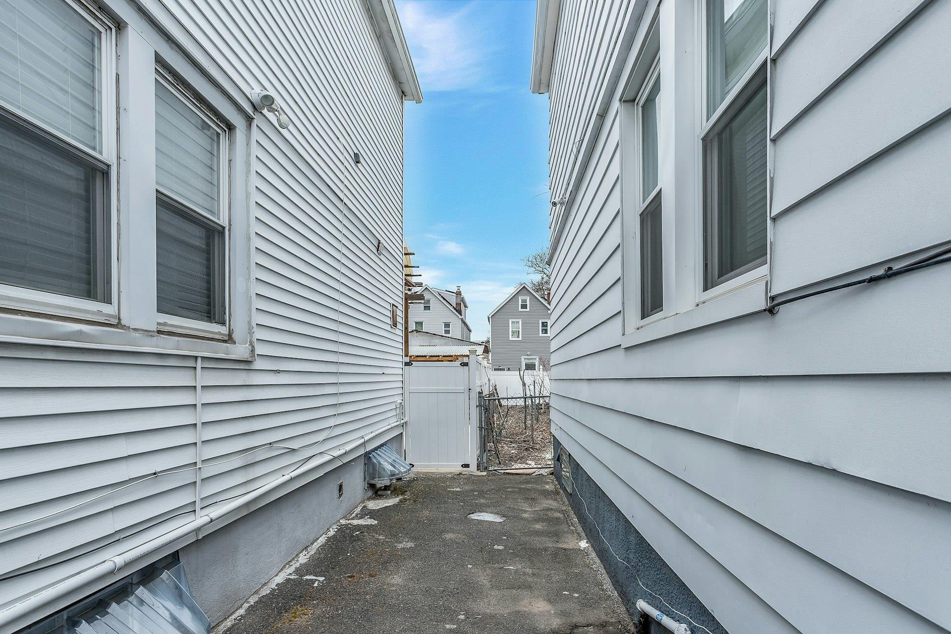 111-32 147th Street Queens, NY 11435 - Photo 23 of 24 View of side of property featuring a gate and fence