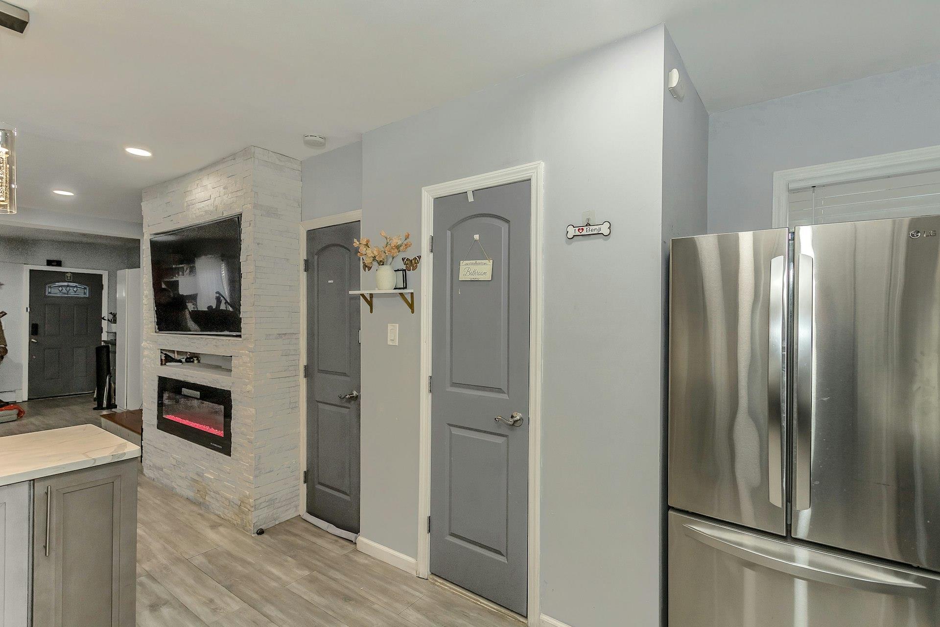 111-32 147th Street Queens, NY 11435 - Photo 6 of 24 Kitchen featuring light wood-type flooring, freestanding refrigerator, recessed lighting, a large fireplace, and baseboards